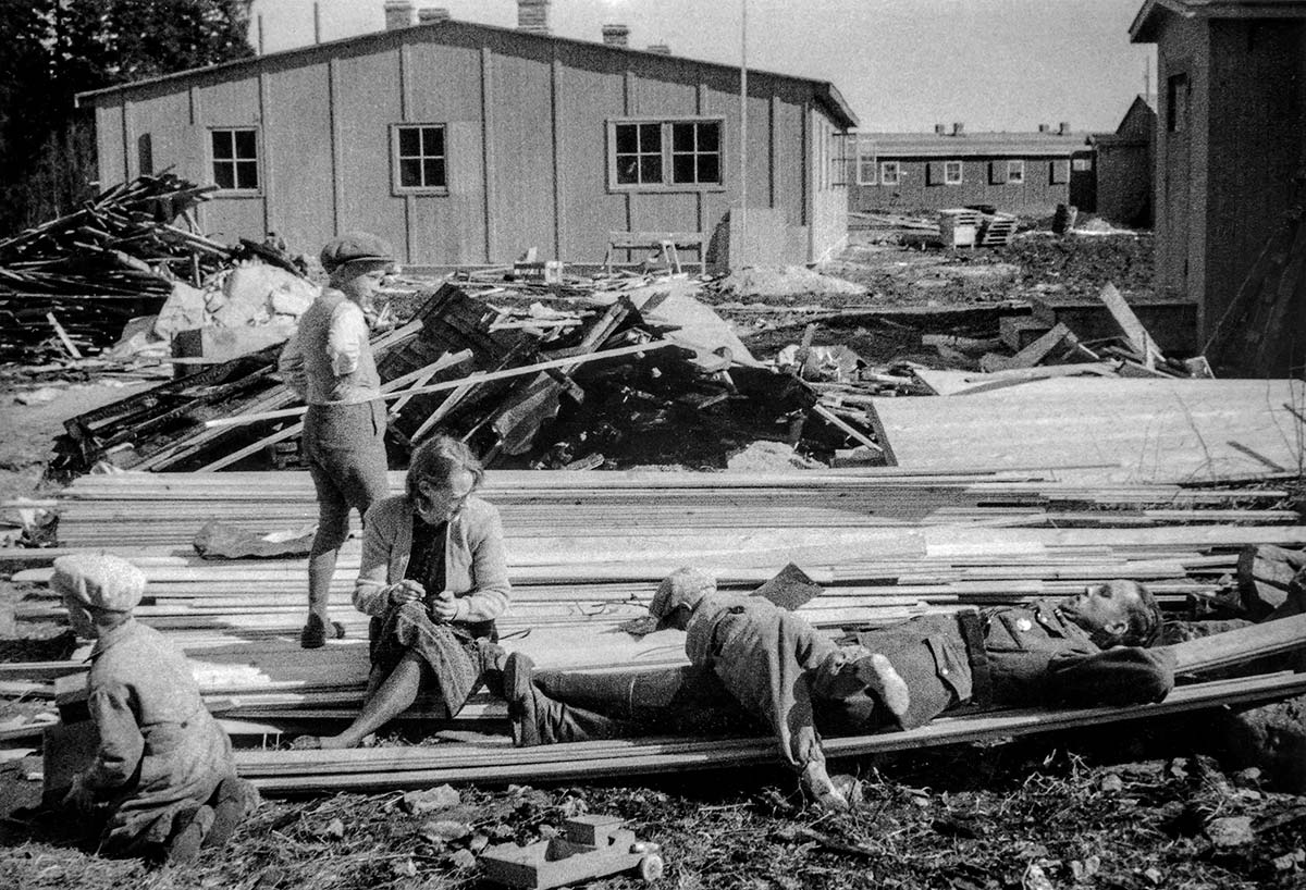 Saksalaisten parakkeja rakennetaan Rovaniemen Veitikantiellä vuonna 1942. Leikkimässä lautapinoilla rovaniemeläinen Kailan perhe. Lapin maakuntamuseon kokoelmat.